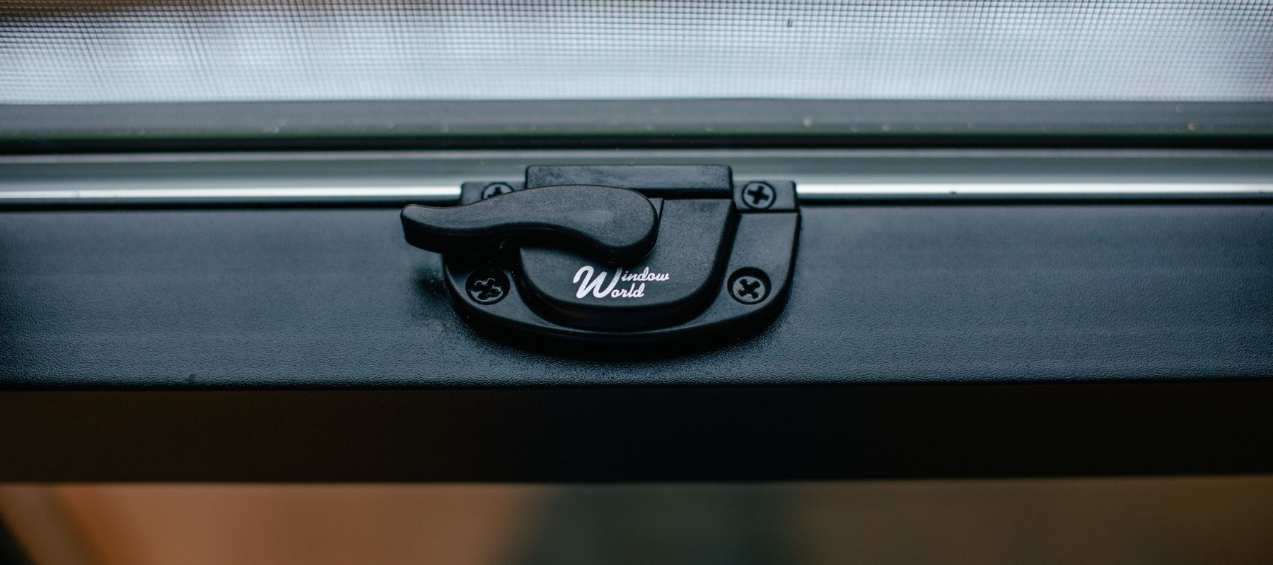 A close-up shot of a black window latch with 